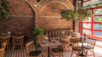 A restaurant interior with brick walls, wooden furniture, and a checkered floor.