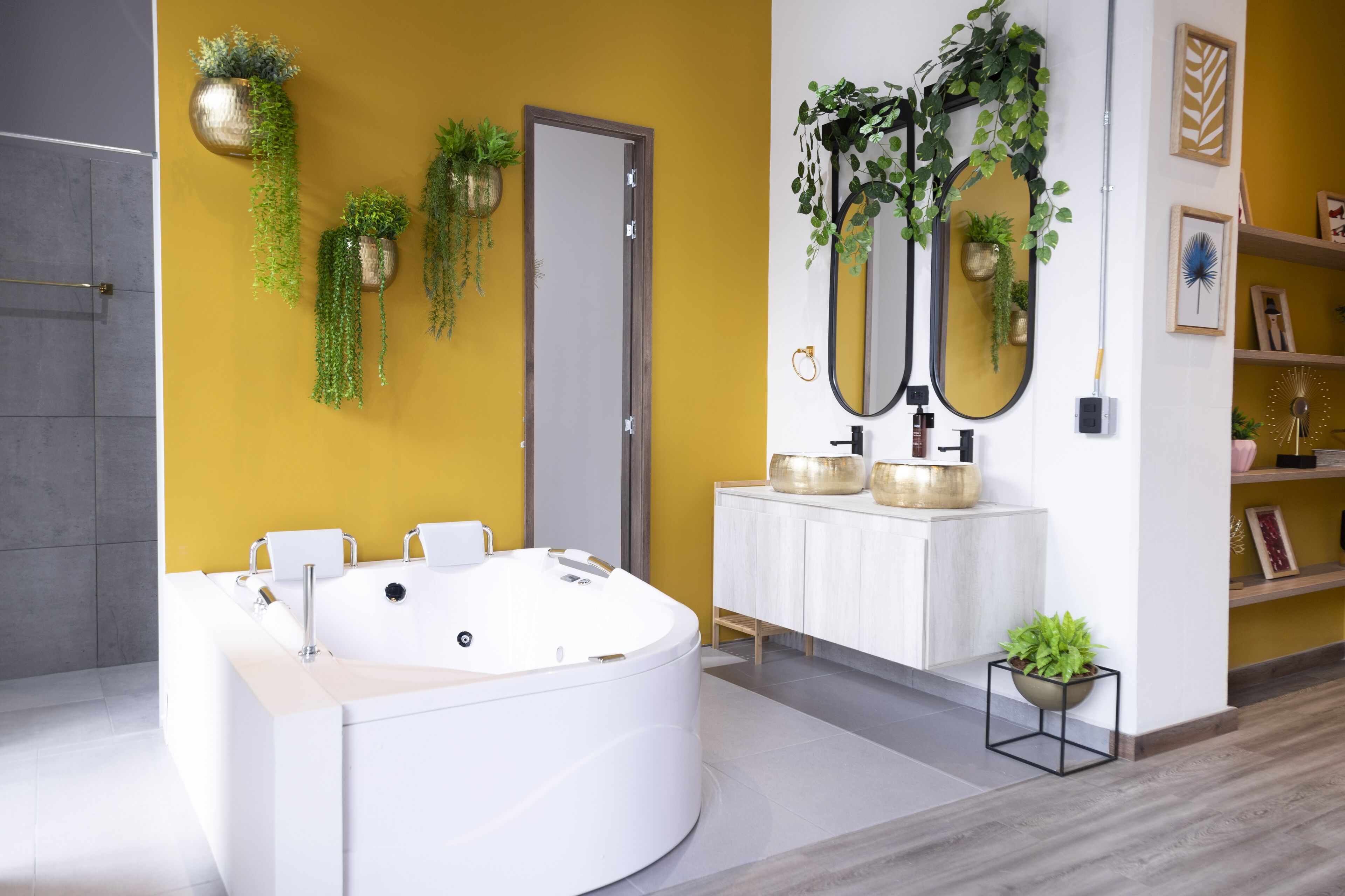Une salle de bain moderne avec une grande baignoire, un meuble-lavabo blanc et plusieurs miroirs.
