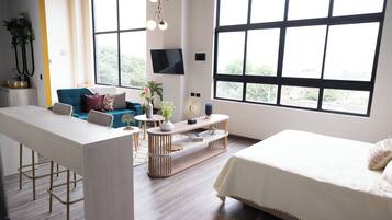 A modern living room with a sofa, coffee table, and a TV mounted on the wall.