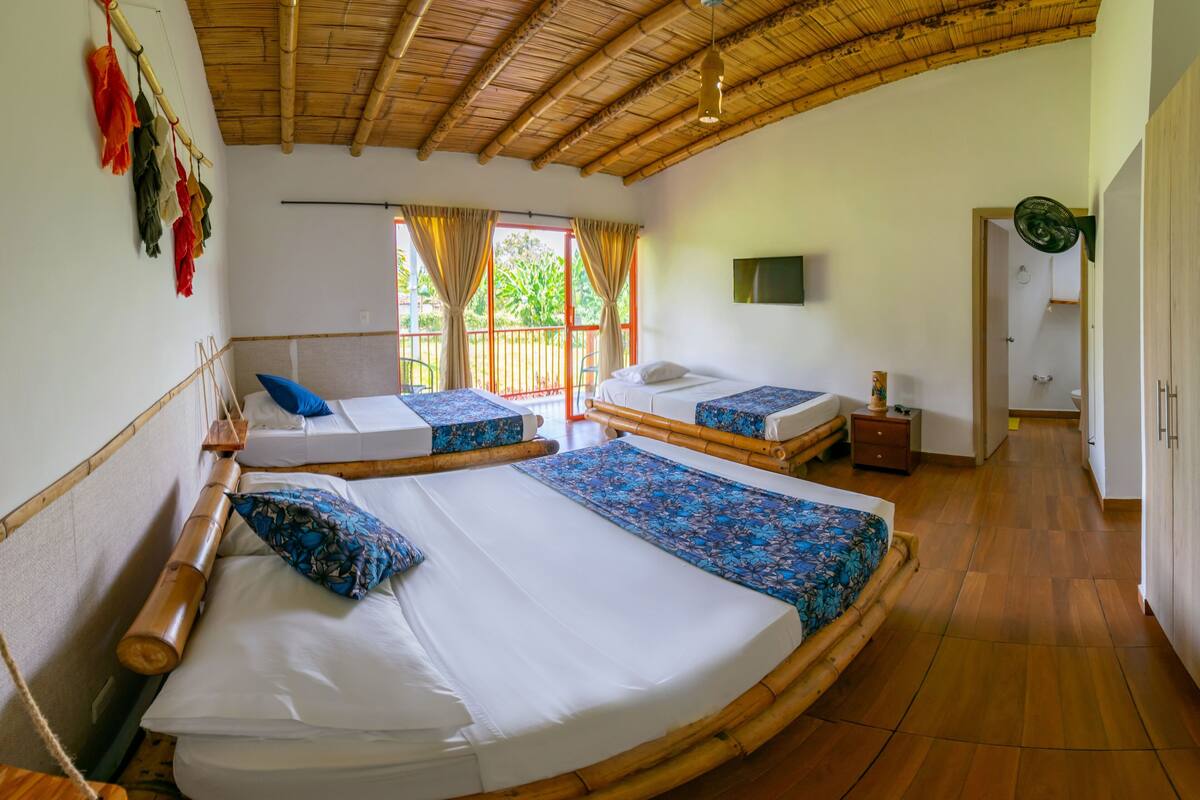 A room with two beds, a TV, and a door leading to the bathroom.