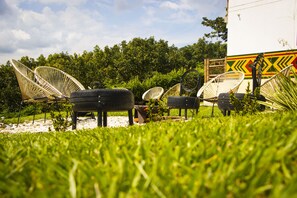 Outdoor wicker chairs arranged on a grassy area with a building in the background. - Hotel Campestre La Aldea (Montenegro)