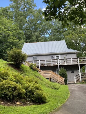 A building with a metal roof, wooden deck, and a sign that reads "Wick".