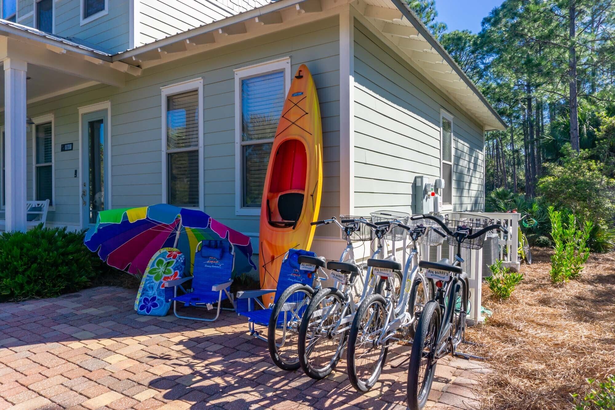 A house with a porch, a kayak, and bicycles.