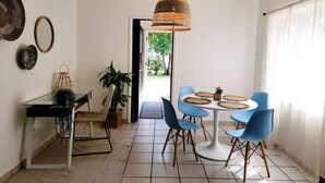 Un comedor con una mesa redonda, sillas azules y una lámpara colgante.