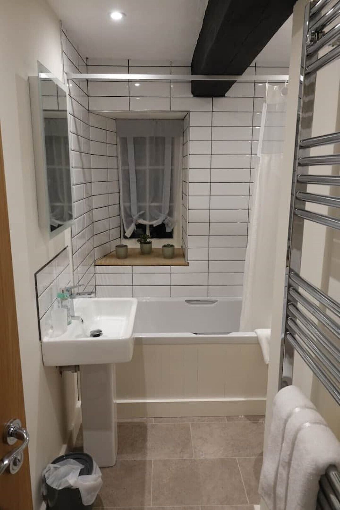 A bathroom with a white sink, a bathtub, and a shower area.