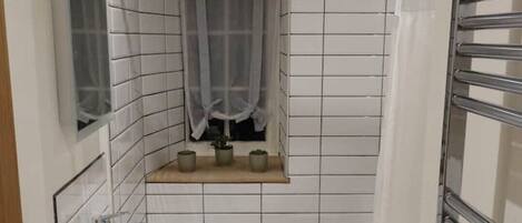 A bathroom with a white sink, a bathtub, and a shower area.