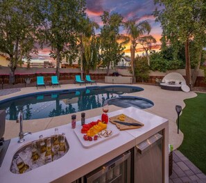 An outdoor pool area with a bar, lounge chairs, and a sunset view. - Scottsdale Oasis-Heated pool/Spa (Scottsdale)