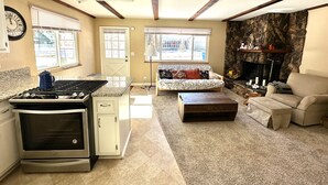 Ein großzügiger Wohnbereich mit Küche, Kamin und einer Couch.