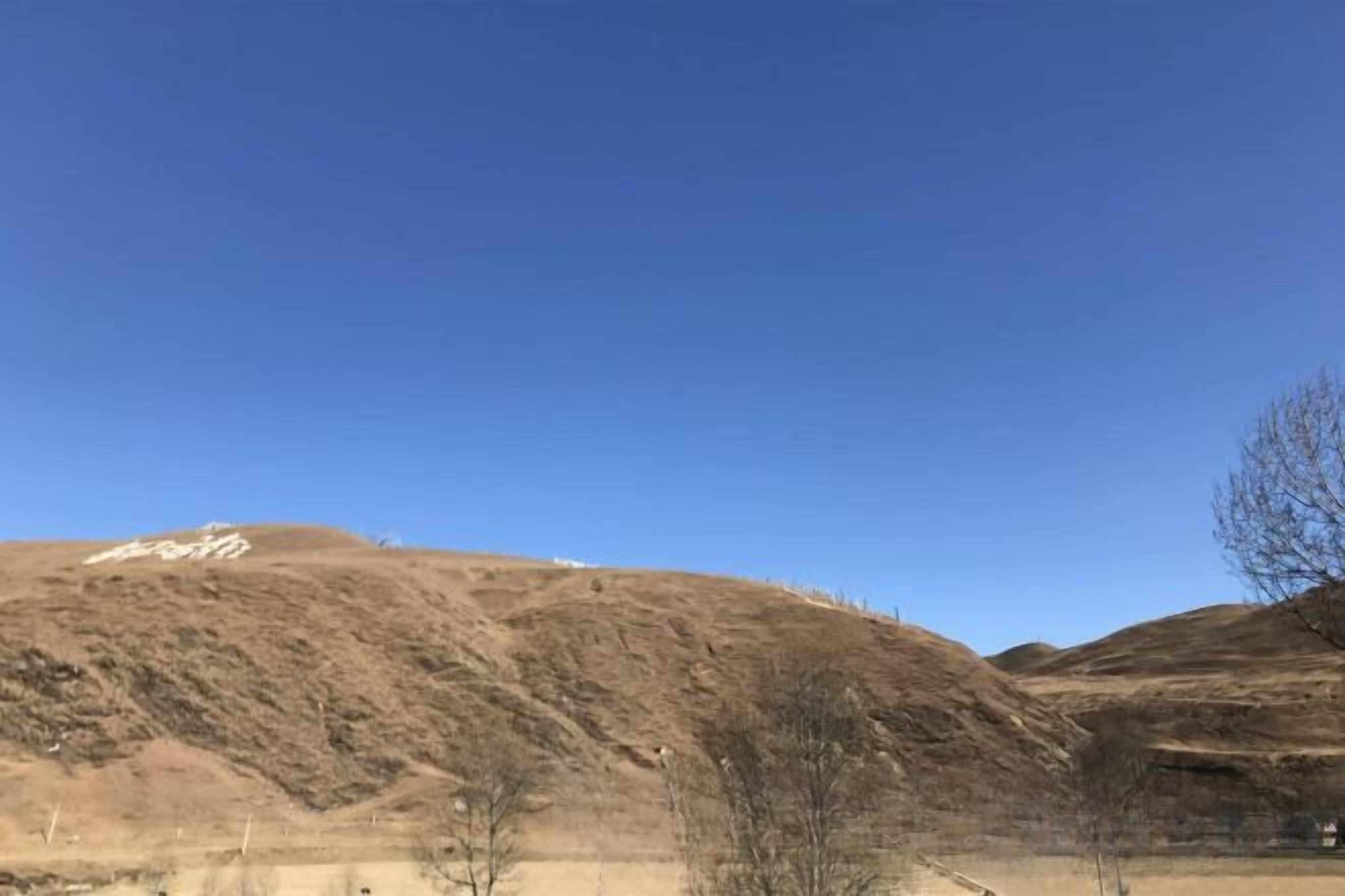 Un paysage vallonné sous un ciel dégagé.