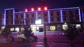 A building with illuminated signage and a crosswalk in front. - Sanbao Ruixiang Business Hotel (Daofu)