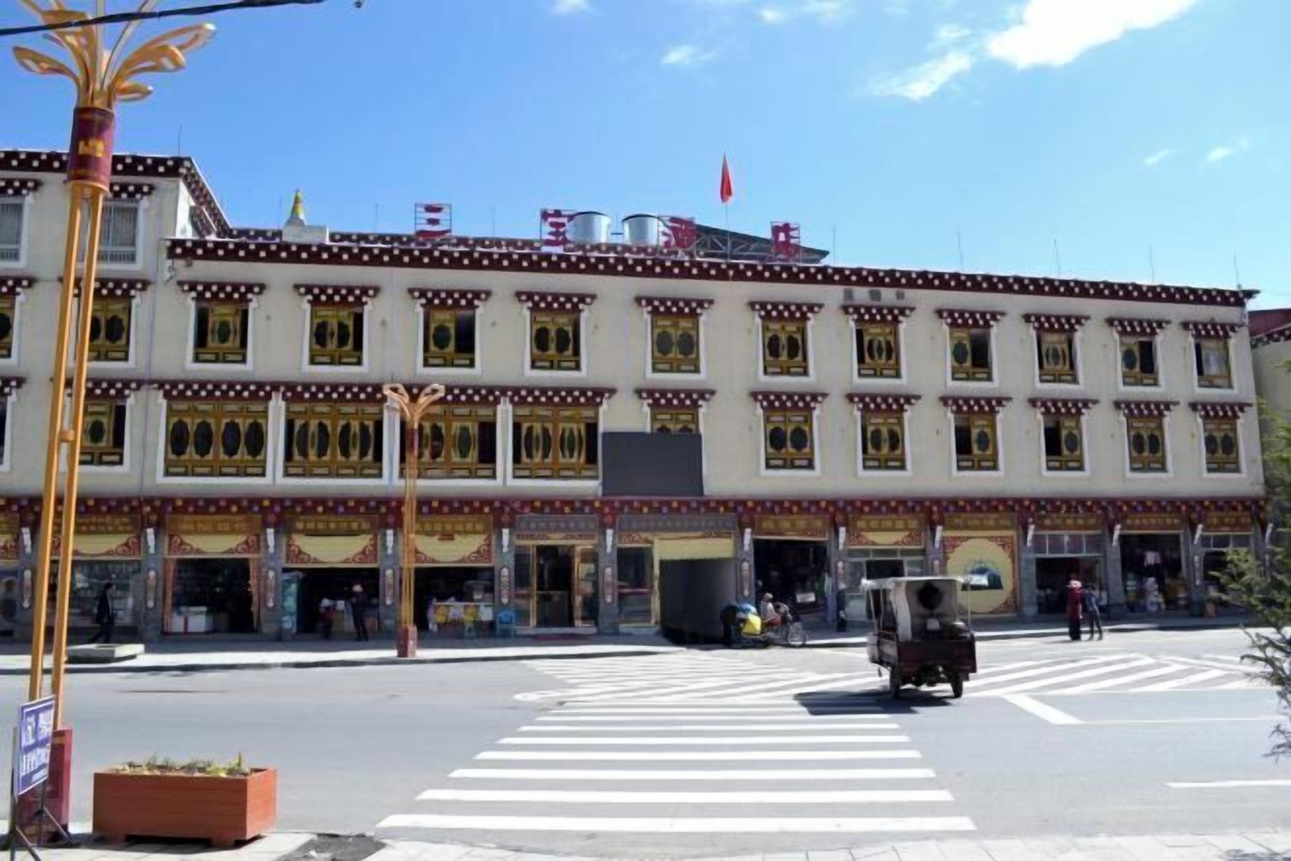 Un edificio de varios pisos con características arquitectónicas tradicionales, como ventanas ornamentadas y un techo plano.