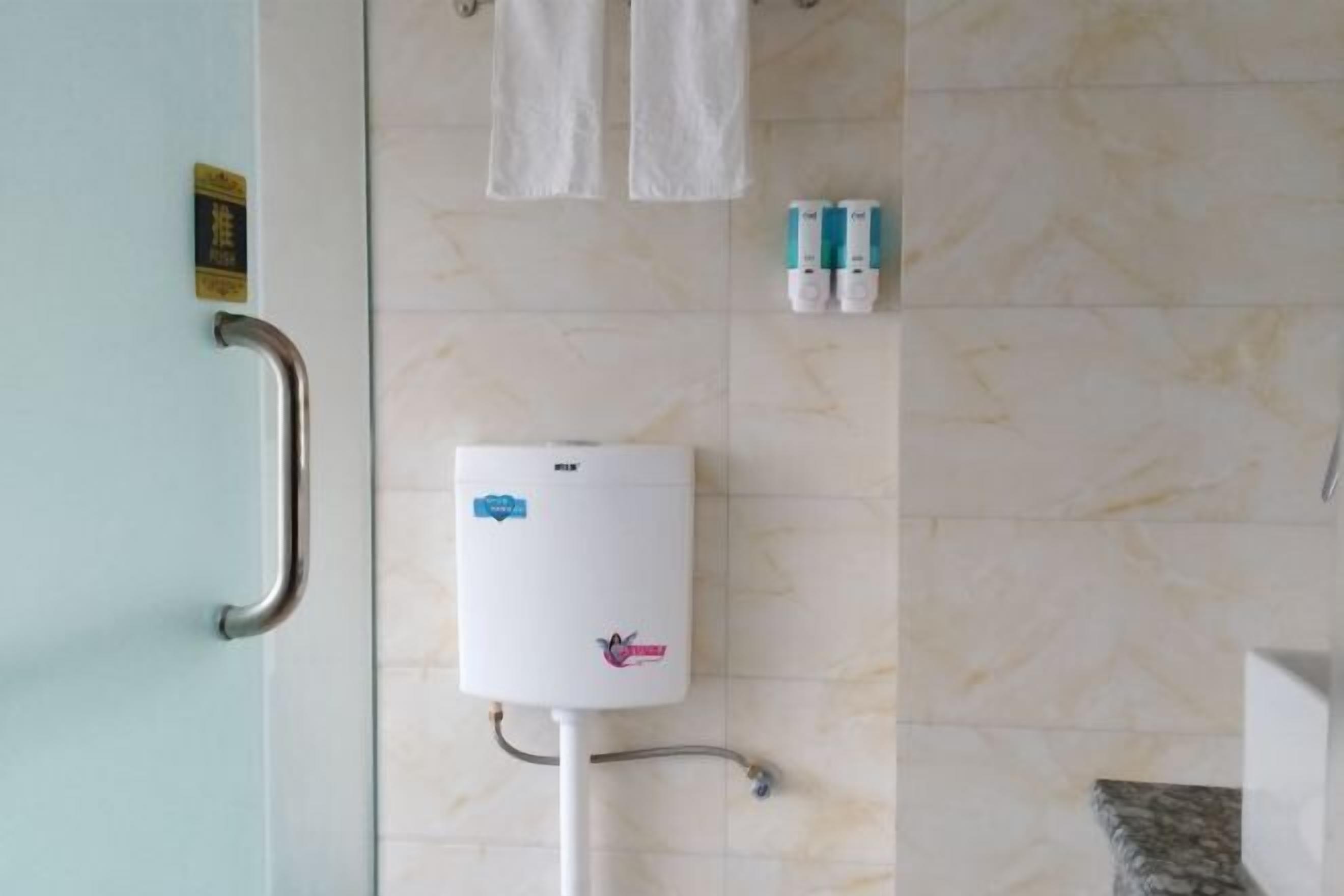 Een badkamer met een handgreep, een boiler en twee flesjes handdesinfectiemiddel.