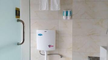 Een badkamer met een handgreep, een boiler en twee flesjes handdesinfectiemiddel.
