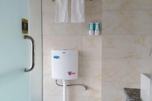 Une salle de bain équipée d’une barre d’appui, d’un chauffe-eau et de deux flacons de gel hydroalcoolique.
