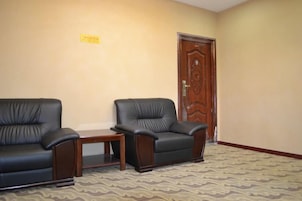 Una habitación con dos sillones de cuero, una mesita y una puerta de madera.