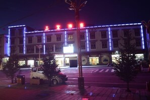 A building with illuminated signage and a crosswalk in front. - Sanbao Ruixiang Business Hotel (Daofu)