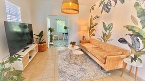 Un salon avec un canapé, une télévision et des plantes.