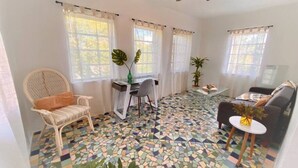 Un salon avec un sol en mosaïque, un ventilateur de plafond et un canapé.