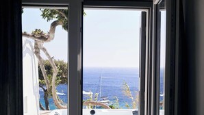 Una habitación con puerta corrediza de vidrio que da a un área de piscina con jacuzzi y vista al océano.