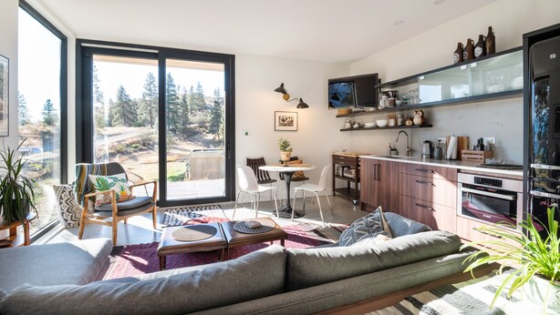 A modern kitchen with a large window, a dining area with a table and chairs, and a living room with a sofa and a coffee table. - Private suite 2 bedroom in the Southern Okanagan BC reg #H082210588 (Oliver)