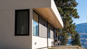 A modern building with large windows and a wooden overhang. - Private suite 2 bedroom in the Southern Okanagan BC reg #H082210588 (Oliver)