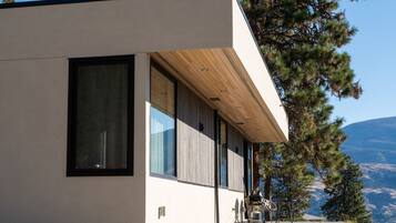 Un bâtiment moderne doté de grandes fenêtres et d’un auvent en bois.