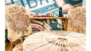 A room with floral-patterned chairs, a round woven table, and a wall with a large 'LIBA' sign. - Relax in Style at Our 3BR/2BA Retreat with Private Pool|Game Room|Fire Pit|Yoga (Tampa)