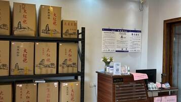 A reception area with a wooden desk, a computer, and a bulletin board with informational posters.