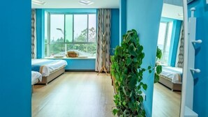 A modern hotel room with two beds, a large window, and a potted plant. - Wuyi Mountain Ruilan Chasu (Wuyishan)
