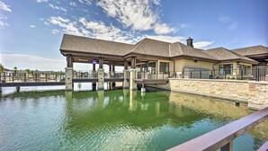 A building with a covered outdoor area and a pool. - Balcony & Lake View: Modern Condo in Monkey Island (Monkey Island)