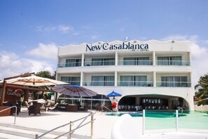 A hotel with a pool area, outdoor seating, and a bar. - NEW CASABLANCA PRAIA HOTEL LTDA (Paulista)