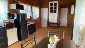Ein Holzblockhaus-Innenraum mit Küche, Essbereich und zwei Schlafzimmern.