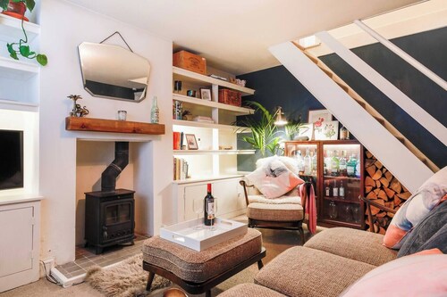 Juniper Cottage is a quaint, two-bedroom Grade II listed property featuring white wooden cladding.