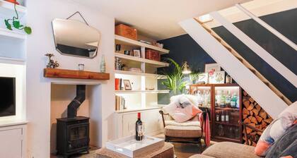 Juniper Cottage is a quaint, two-bedroom Grade II listed property featuring white wooden cladding.