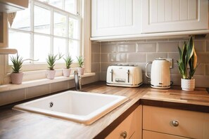 Fridge, oven, stovetop, dishwasher - Juniper Cottage is a quaint, two-bedroom Grade II listed property featuring white wooden cladding. (Whitstable)