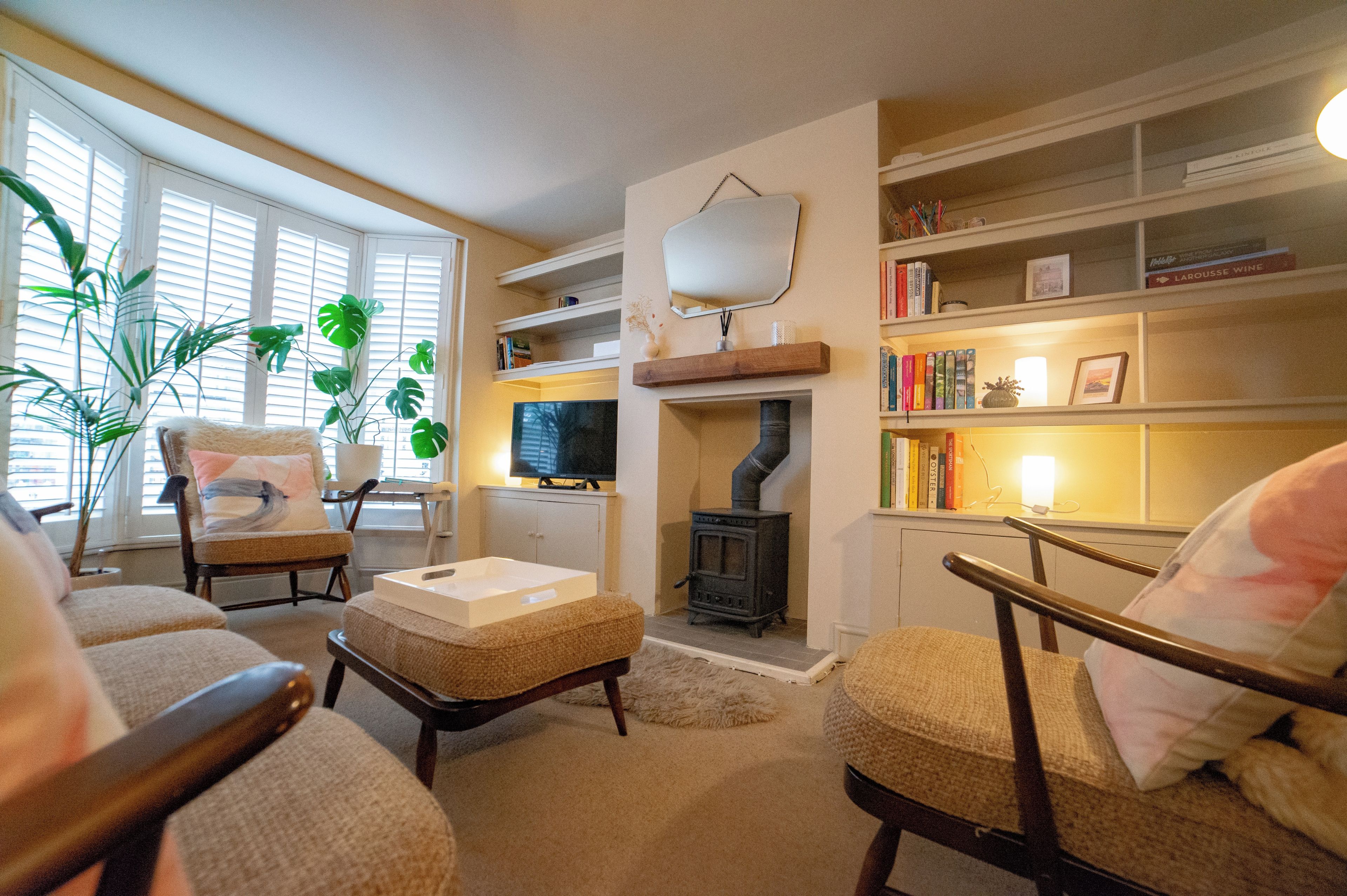 A cozy living room with a fireplace, comfortable seating, and a bookshelf.