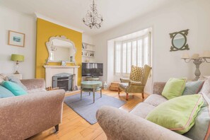 A living room with a fireplace, television, and comfortable seating. - Harbour House is a lovingly refurbished and centrally located beautiful three storey house, sleeping 9 guests, with private parking. (Whitstable)