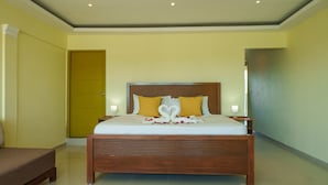 A neatly arranged bedroom with a wooden bed, a bedside table, and a bench. - La Casona MC (La Romana)