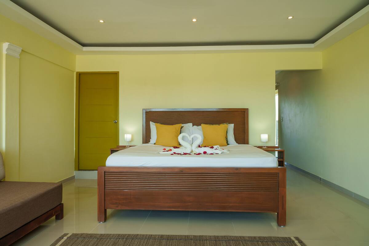 A neatly arranged bedroom with a wooden bed, a bedside table, and a bench.