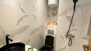 Une salle de bain avec un lavabo, des toilettes et une douche, tous de couleur noire.