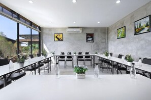 A conference room with a long table, chairs, potted plants, and artwork on the walls. - White Knot Khao Yai (Pak Chong)