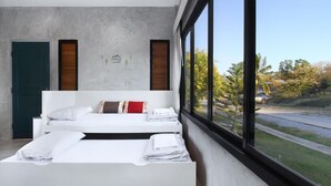 A modern bedroom with two beds, a large window, and a wall with a mountain and trees design. - White Knot Khao Yai (Pak Chong)