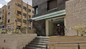 A multi-story building with a modern design, featuring a glass entrance and a staircase leading to the entrance. - Dara apartment hotel (Amman)