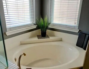 A modern bathroom with a freestanding bathtub, a potted plant, and large windows. - Family Fun Oasis Pool +Hot Tub+ Game Room + Fire Pit +Fast Wi-Fi +Dog Friendly! (Mansfield)