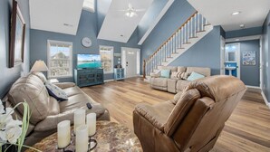 A spacious living room with leather sofas, a marble coffee table, and a ceiling fan. - 5BR Beach House w/ Heated Pool | Great Views! (North Myrtle Beach)
