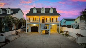 A two-story house with a balcony, a garage, and a driveway. - 5BR Beach House w/ Heated Pool | Great Views! (North Myrtle Beach)