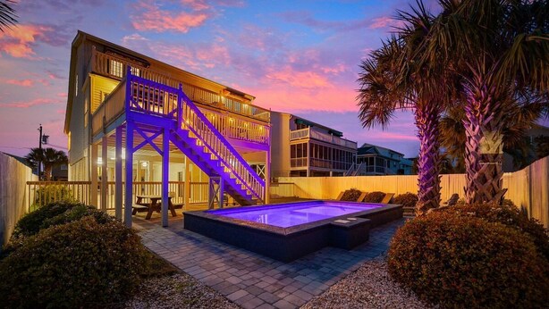 A modern building with a staircase, a pool, and surrounding landscaping. - 5BR Beach House w/ Heated Pool | Great Views! (North Myrtle Beach)