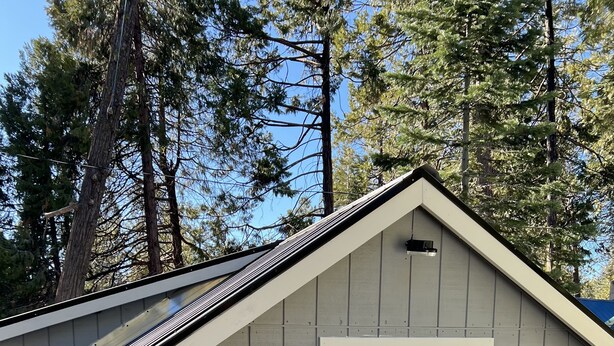 En liten, envåningsbyggnad med en vit dörr och en rund skylt med texten ”Cory Shaver Studio”.