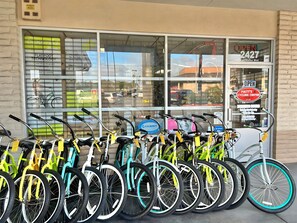 A row of bicycles parked outside a store with a large window and a sign indicating 'Matt's Cycling Center'. - Cozy Beach View Loft, 42 Steps to the Sand + AC (Ventura)