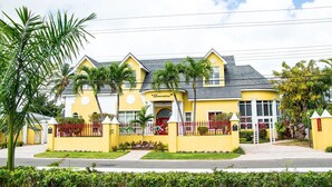 A yellow building with a red door and a sign that reads "Bonaventure." - Sunset Loft (Nassau)